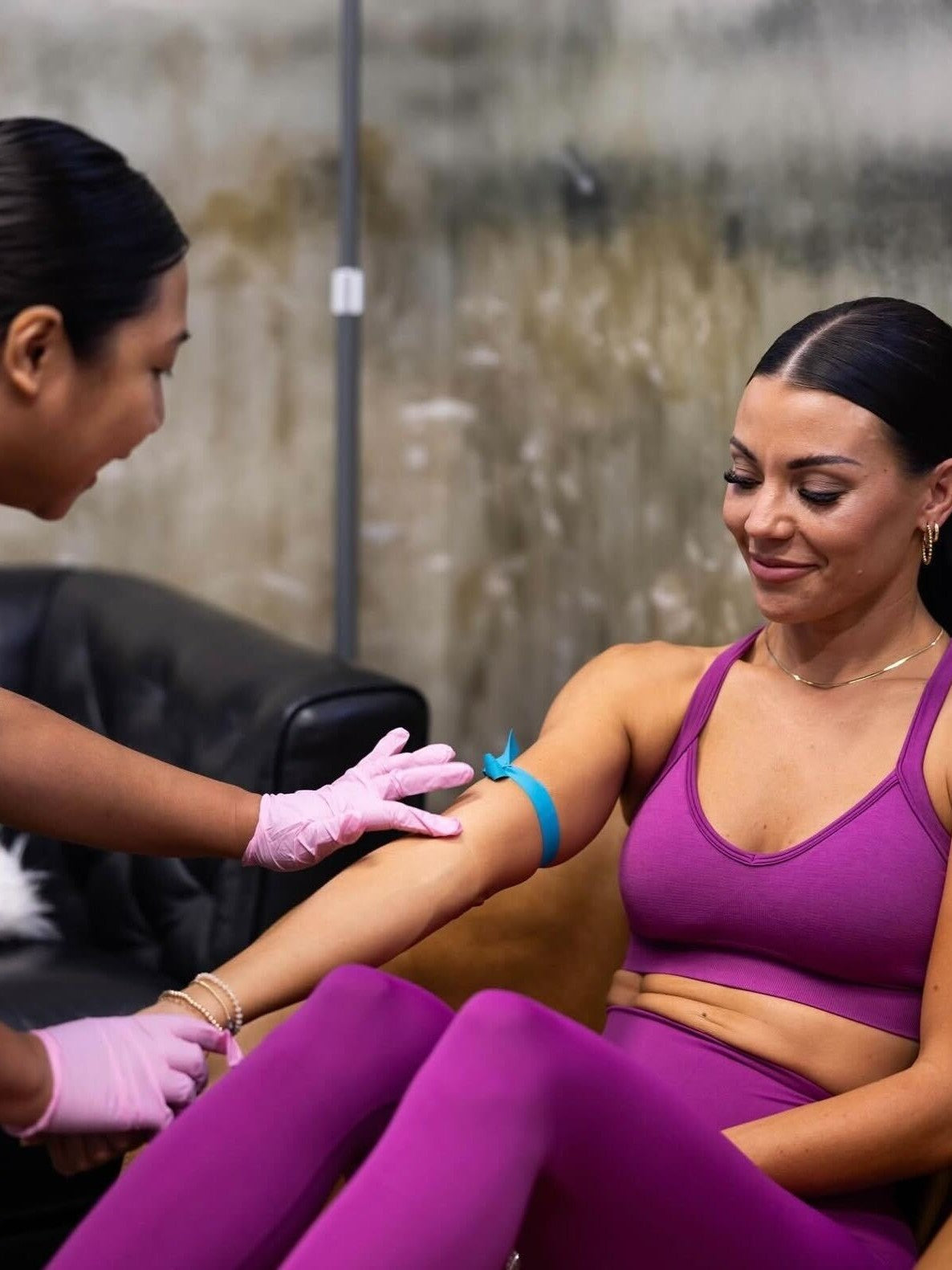 Woman in purple athletic wear receiving a blood draw